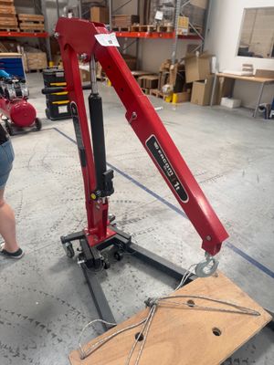 une femme qui se tient à côté d'une grue rouge