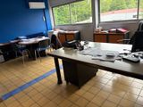 des tables et des chaises dans une pièce aux murs bleus et dotée d'une grande fenêtre
