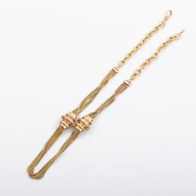 un collier en or composé d'une longue chaîne et d'un nœud