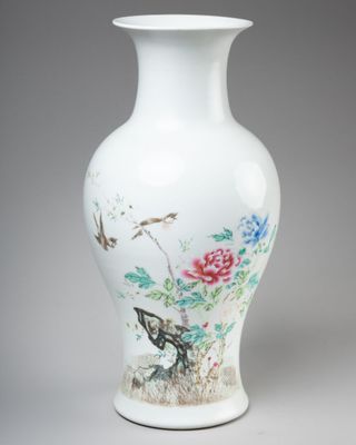 un vase blanc avec des fleurs et des oiseaux peints dessus
