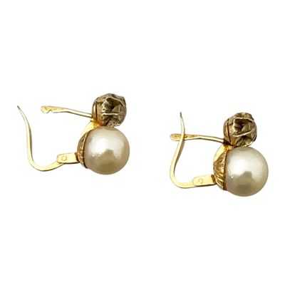 une paire de boucles d'oreilles en perles et en or sur fond blanc