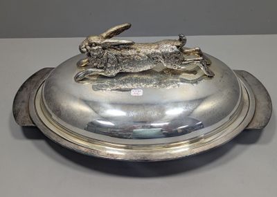 un plateau en argent orné d'un lapin, posé sur une table