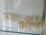 a lot of glasses that are sitting on a glass shelf