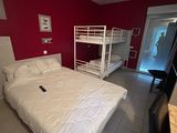une chambre avec un lit et des lits superposés
