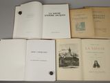 several open books sitting on top of each other on top of a table