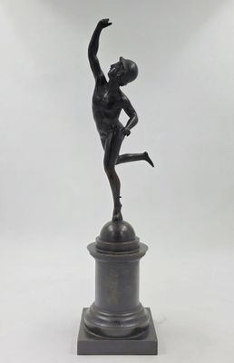 statue en bronze représentant un garçon tenant un ballon de basket sur un socle