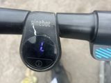 un gros plan sur un guidon de vélo sur lequel est fixée une lumière bleue