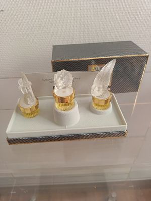 une vitrine en verre sur laquelle sont posées trois figurines en verre