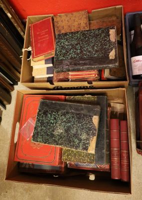 two boxes full of books and a bottle of wine on the floor