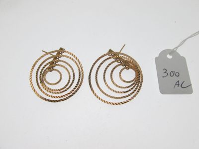 une paire de boucles d'oreilles créoles dorées en fil torsadé