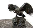 a statue of an eagle on a rock with its wings spread