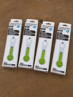 four green toothbrushes in a package on a wooden surface