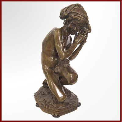 statue en bronze représentant un homme assis sur un livre, la main posée sur le visage