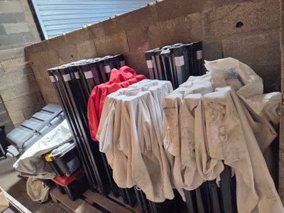 une pile de vêtements posée sur une palette à côté d'un radiateur