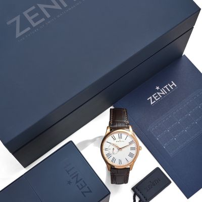 La montre dans son coffret se trouve à côté du contenu de la montre.