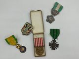 trois médailles et une médaille dans une boîte posée sur une surface blanche