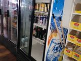 a refrigerator in a store with a lot of drinks on the shelves
