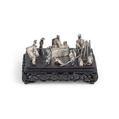 une figurine en argent représentant un groupe de personnes, posée sur une table