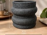 un gros plan sur une pile de bols en granit noir posés sur une table en bois