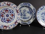three blue and white plates with designs on them on a black surface
