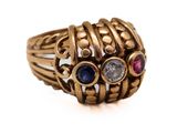 un gros plan sur une bague en or sertie de pierres de différentes couleurs
