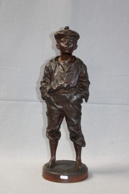 bronze statue of a man with a hat on a wooden base