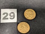 Deux pièces d'or portant le chiffre 29 sont posées à côté d'une étiquette de prix