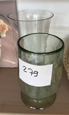 un verre avec une étiquette, posé sur une étagère à côté d'un ours en peluche