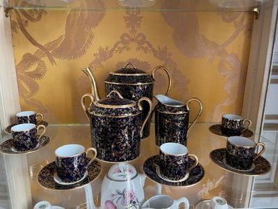 many cups and saucers on display in a glass case