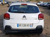 a small white car parked in a lot with other cars