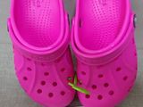 a pair of pink children ' s crocs with a tag on it
