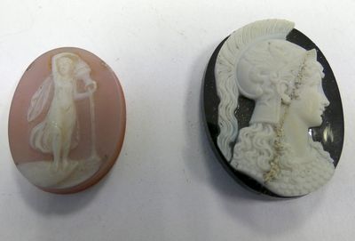 two cameos of women and a man are shown on a white surface