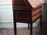 a small desk with a drawer on it in the corner of a room