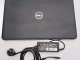 dell laptop computer with power cord and charger sitting on a table