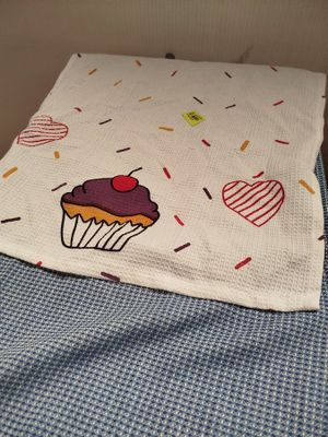 une couverture avec un cupcake dessiné dessus, posée sur un lit
