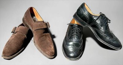 two men ' s shoes are lined up on a white surface