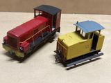 two toy trains sitting side by side on a table