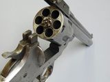 a hand holding a gun that is sitting on a table