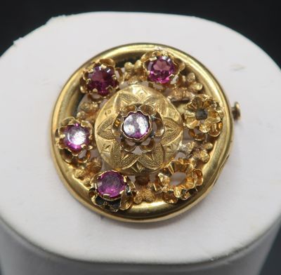 an image of a close up of a gold and pink stone broochle