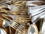 beaucoup de cuillères en argent et de cuillères à soupe sur une table