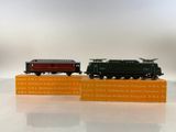 two miniature trains sitting on top of each other on a table