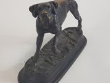statue représentant un chien debout sur une planche de surf, posée sur un fond blanc