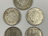 four different types of coins are shown on a white surface