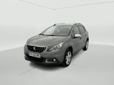 Une voiture grise est garée dans une pièce blanche au sol blanc.
