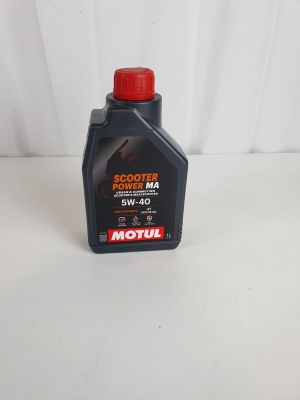 un gros plan d'une bouteille d'huile moteur posée sur une surface blanche