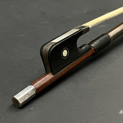 un archet de violon et un repose-archet posés sur une table