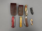 many different types of knives and sheaths laid out on a table
