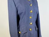 a woman ' s blue jacket with gold buttons on a mannequin dummy
