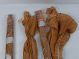 three brown umbrellas wrapped in plastic on a white surface