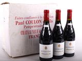 trois bouteilles de vin rouge sont posées devant une boîte blanche